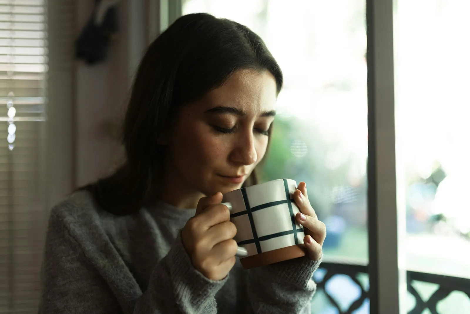 Woman reflecting with a warm drink